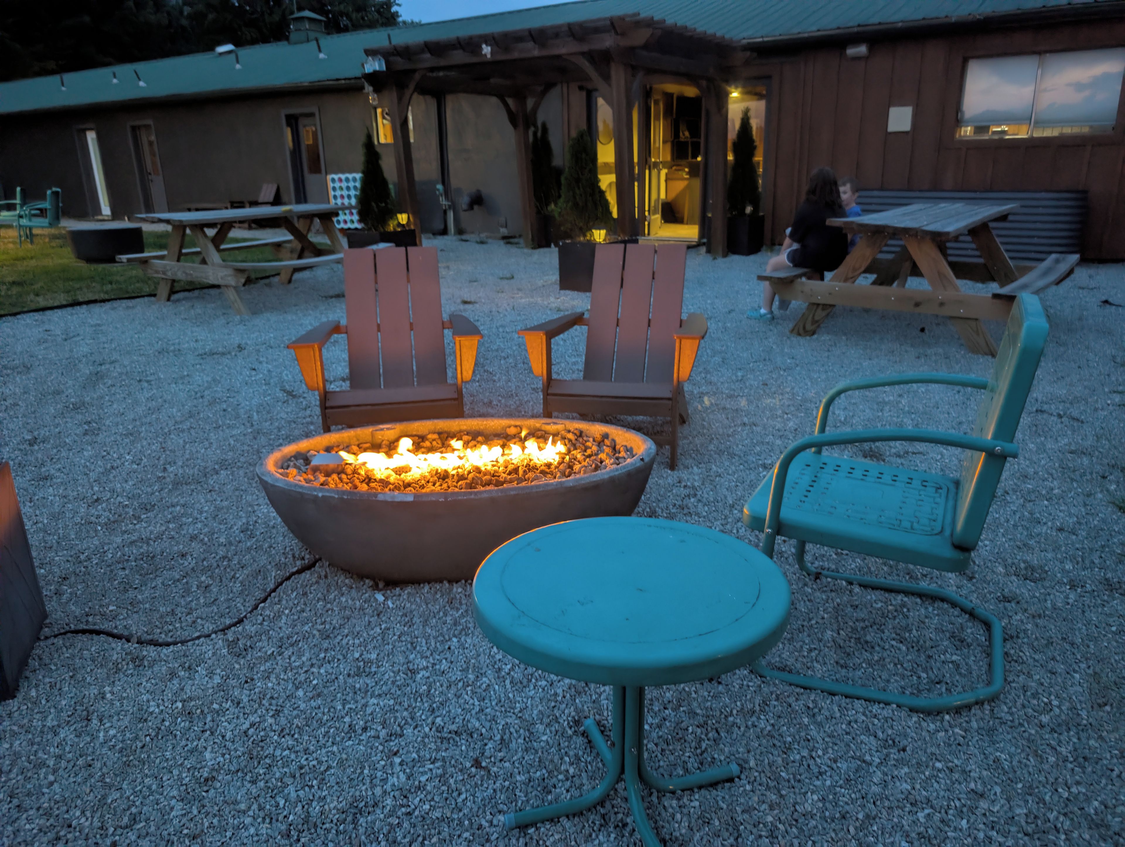 An outdoor seating area with a fire pit, wooden chairs, and a table.