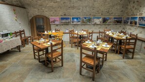 A dining area with stone walls and wooden tables and chairs. - Il Seicento - Hostel (Sernio)