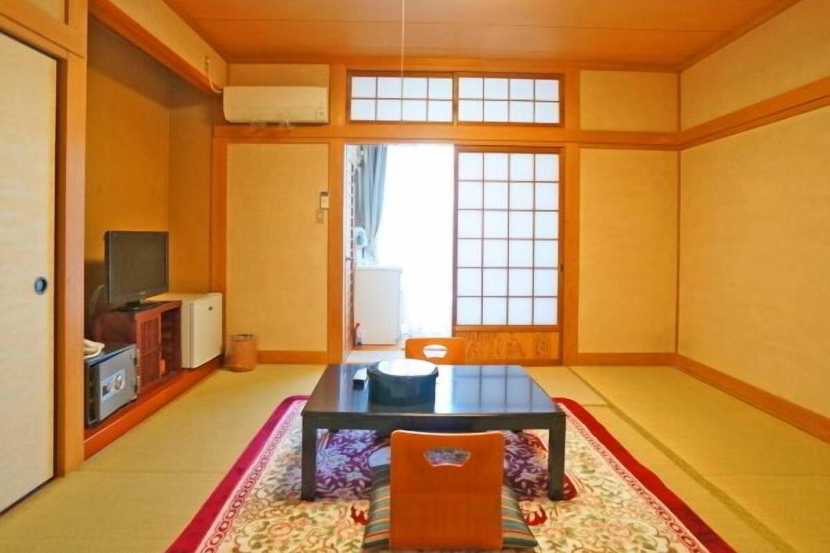 Een traditionele Japanse kamer met tatami vloerbedekking, een lage tafel en een schuifdeur.