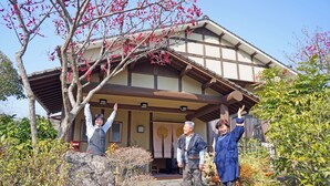 En traditionell japansk byggnad med ett tak täckt av tegelpannor och träbjälkar.