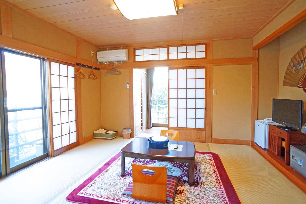 Een traditionele Japanse kamer met tatami vloerbedekking, een lage tafel en schuifdeuren.