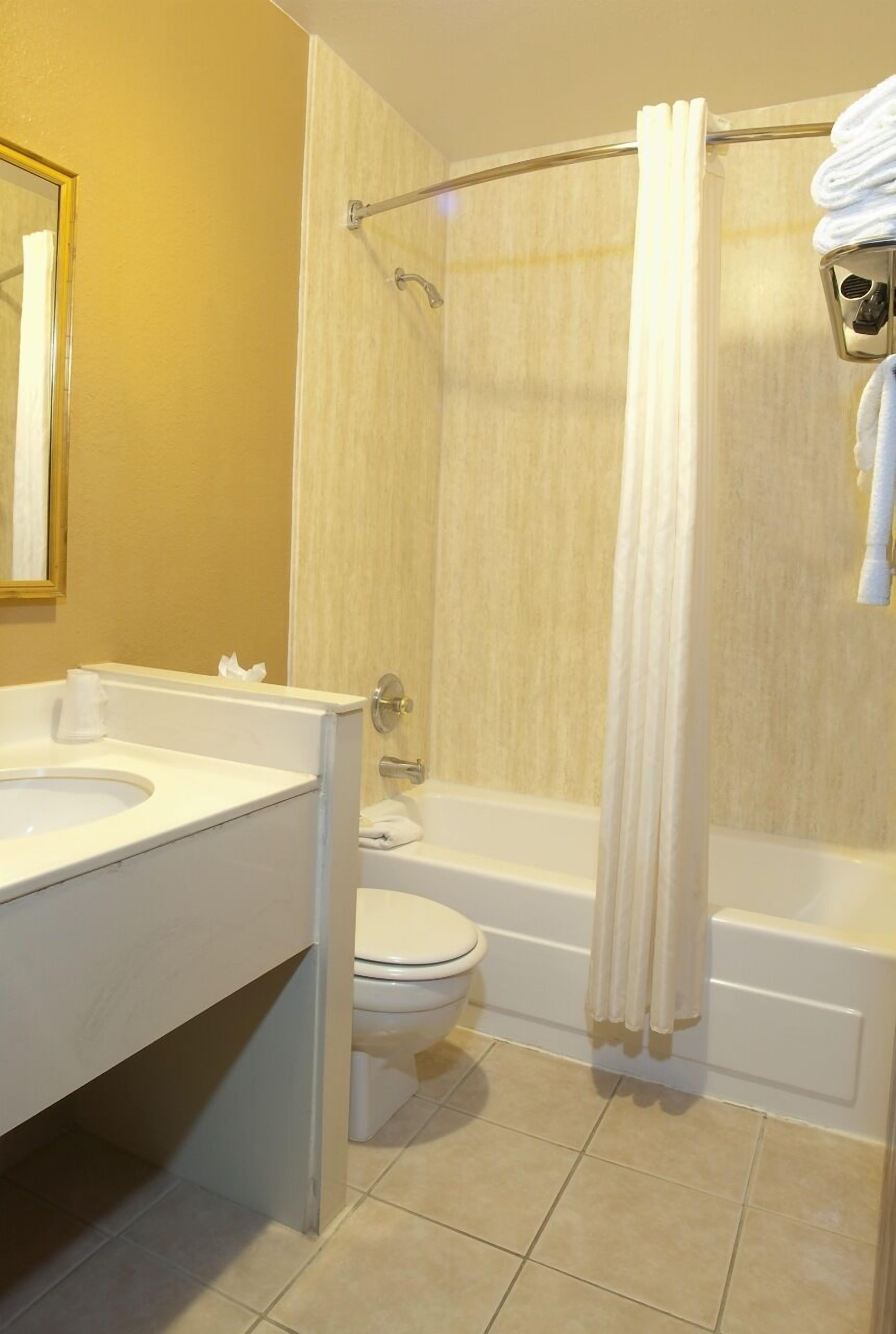 Ein Badezimmer mit einer Badewanne, einer Toilette und einem Waschbecken.