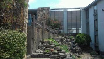 A stone pathway leading to a building with a modern facade and large windows.