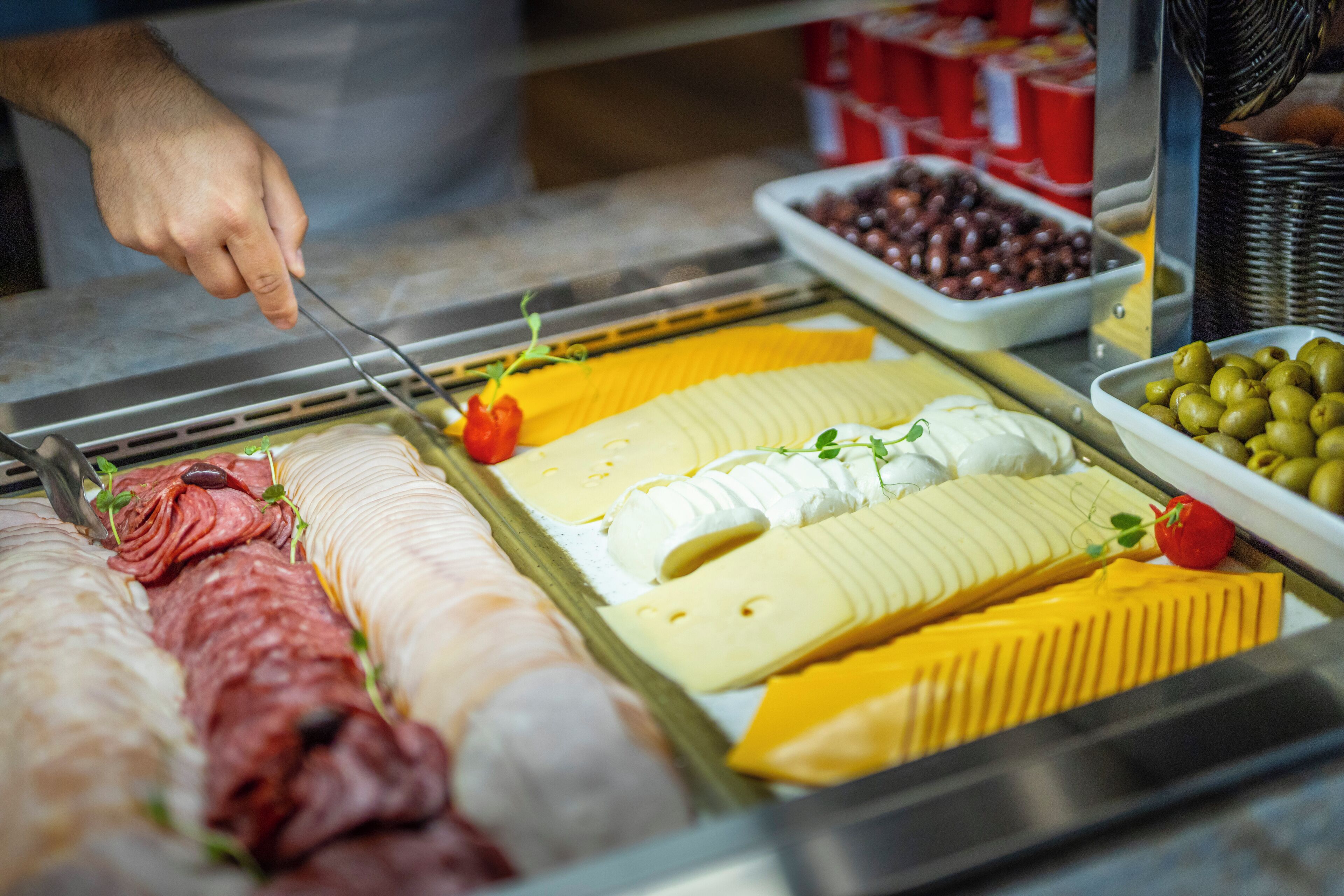 A variety of meats and cheeses on display.