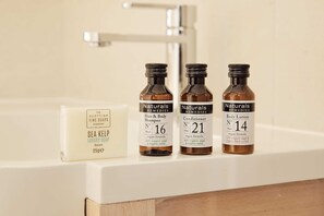 Trois bouteilles de produits de la marque Naturals Remedies sont posées sur le comptoir d’une salle de bain.
