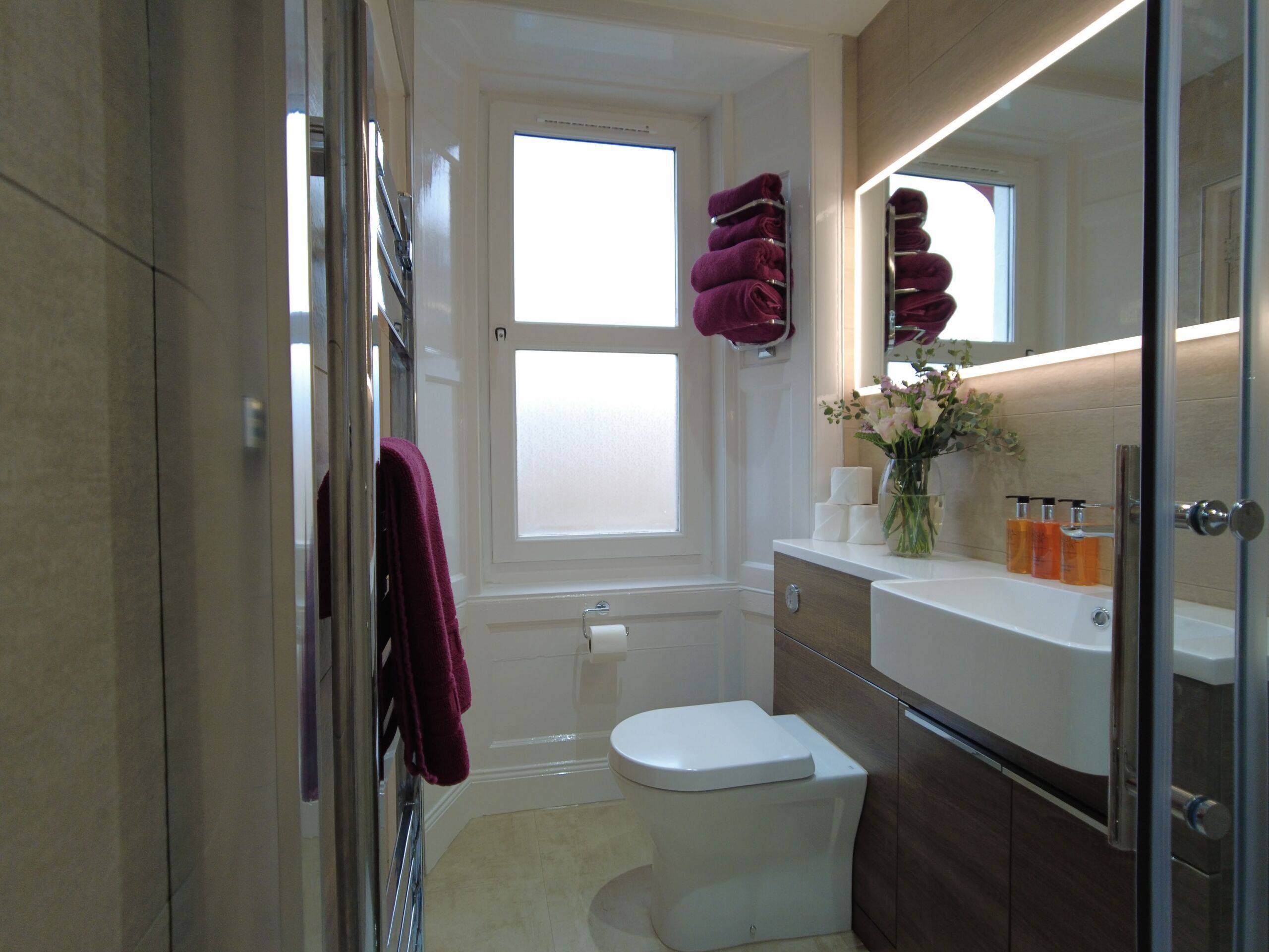 Un baño moderno con inodoro, lavabo y zona de ducha.