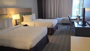 A hotel room with two beds, a desk, a chair, a TV, and a window with curtains. - Country Inn & Suites by Radisson, Belleville, ON (Belleville)