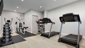 A modern gym with treadmills, weight machines, and free weights.