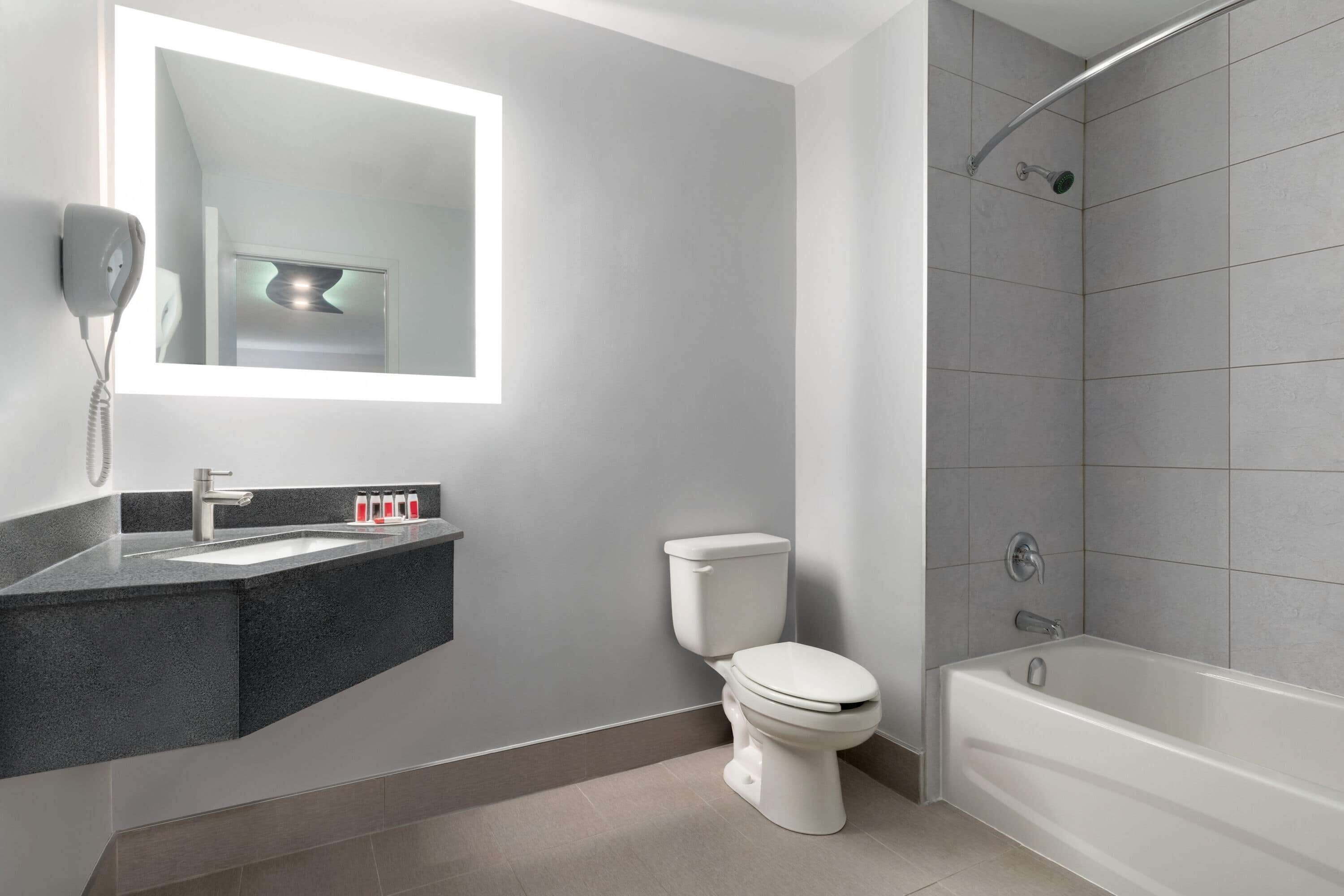 Un baño moderno con inodoro, lavamanos y bañera.