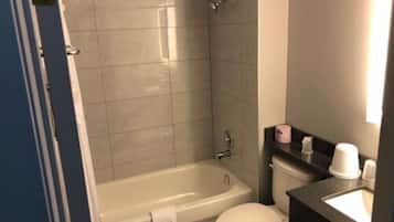 A bathroom with a bathtub, toilet, and sink.