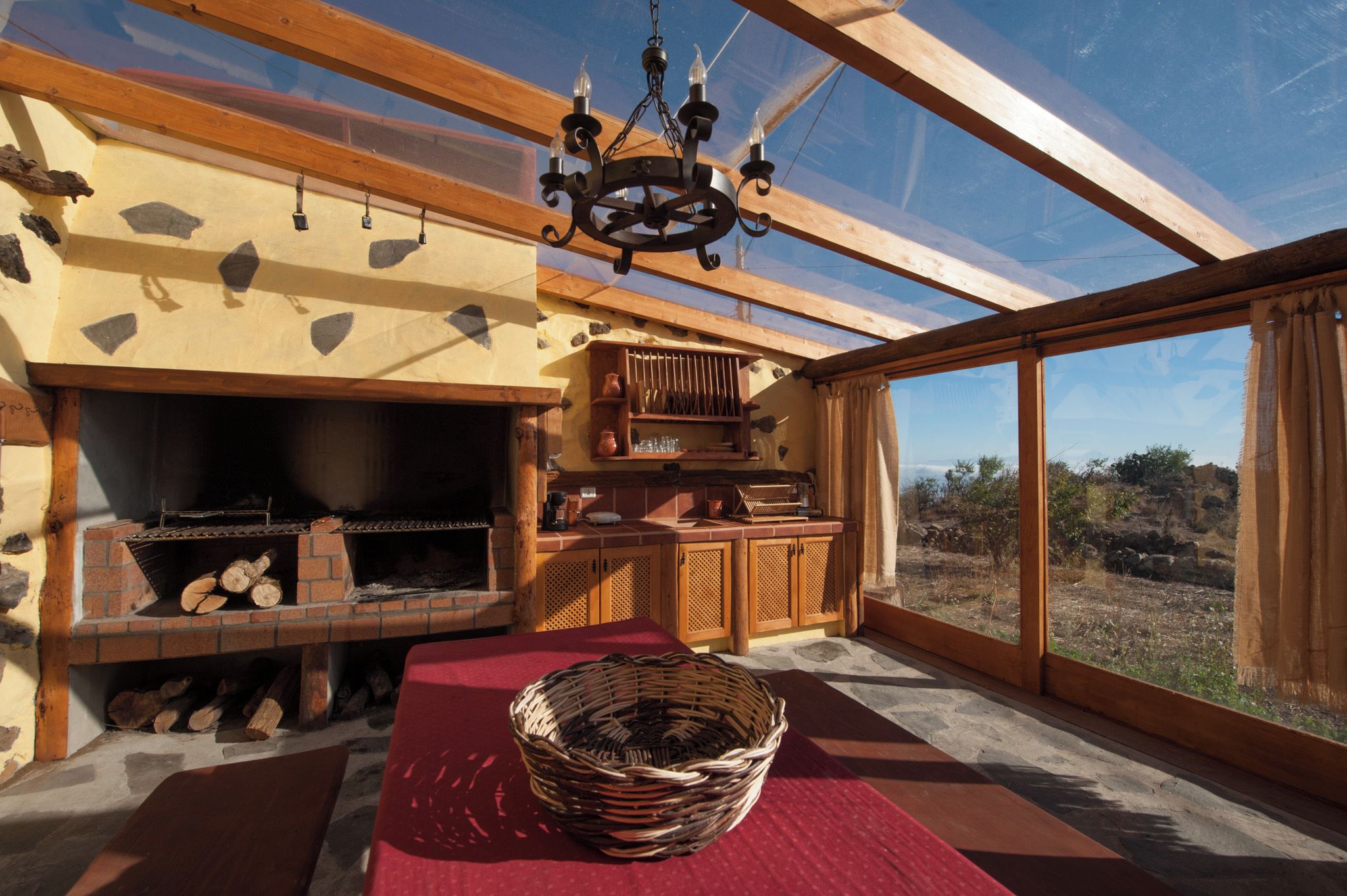 A room with a fireplace, wooden furniture, and a large window.