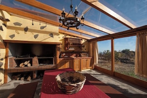 Una habitación con chimenea, muebles de madera y un ventanal grande.
