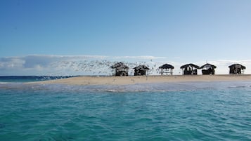 Een privéstrand, wit zand, ligstoelen aan het strand, snorkelen