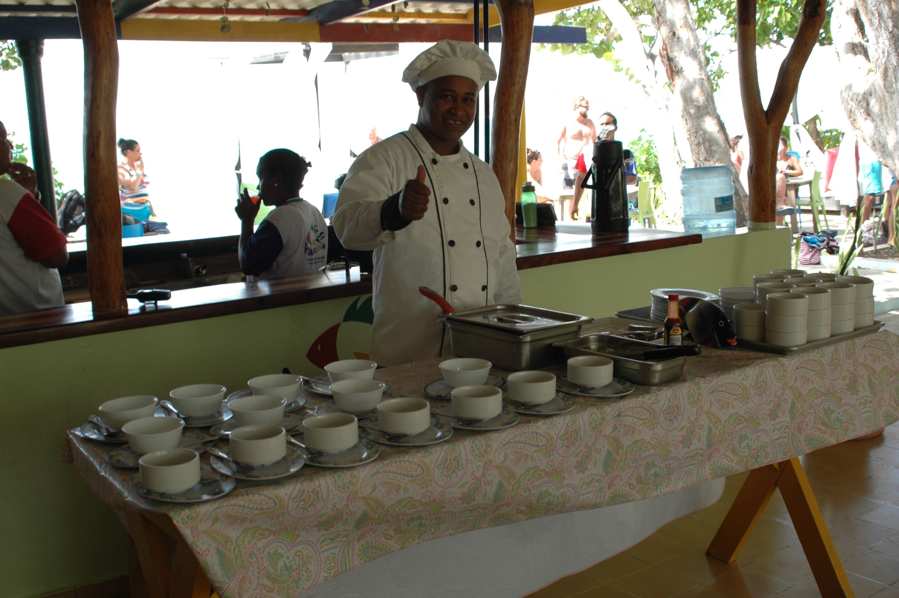 A chef standing behind a buffet table with multiple bowls and plates.