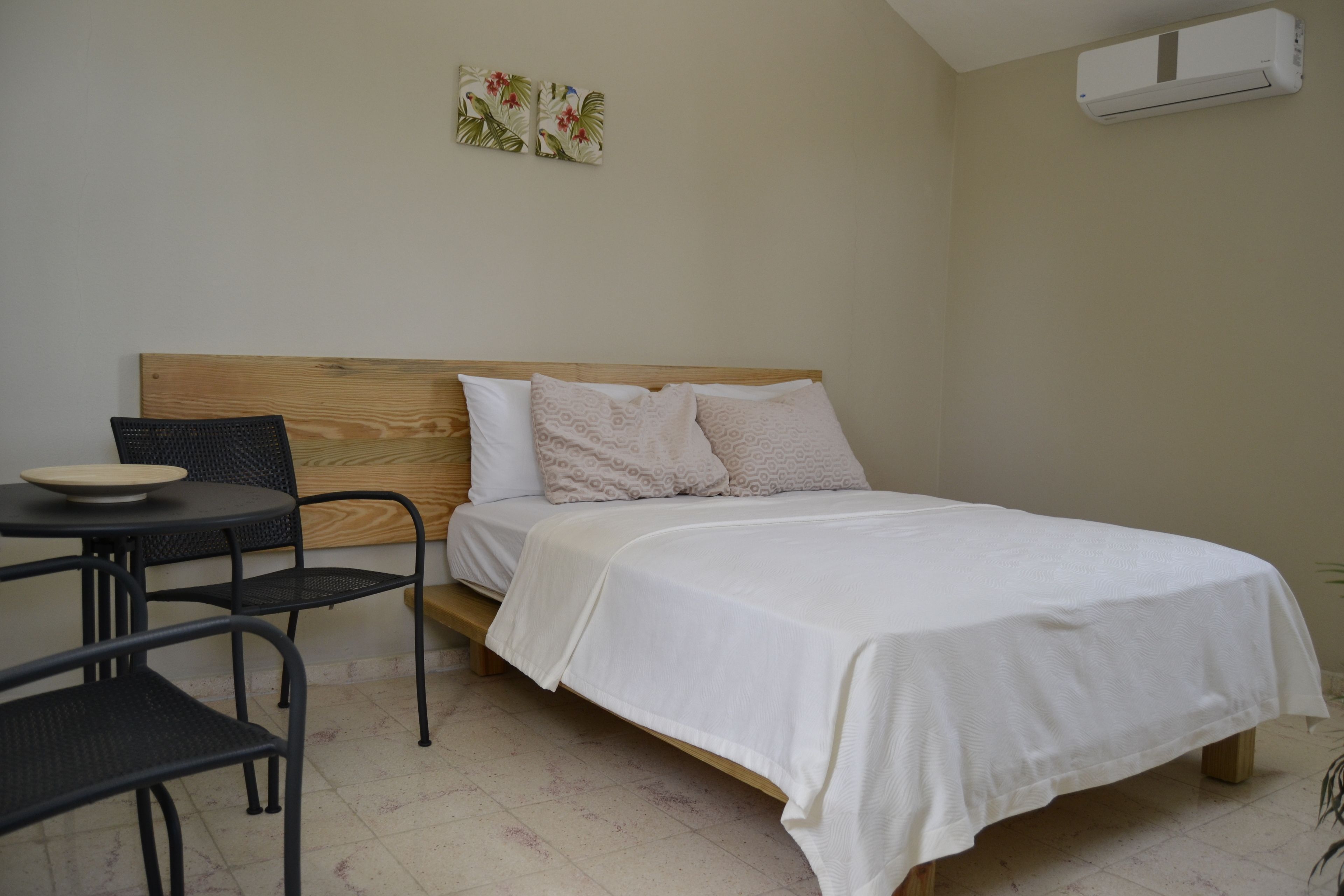 Une chambre à coucher avec un lit, une petite table et deux chaises.