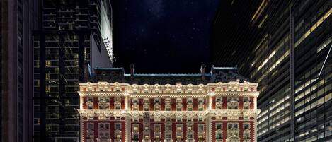 A historic building with ornate architecture, large windows, and a starry night sky in the background.