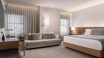 Une chambre d’hôtel moderne équipée d’un grand lit, d’un canapé, d’un bureau et d’une télévision.