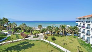 Un resort con vista al mar, palmeras y un edificio con balcones.