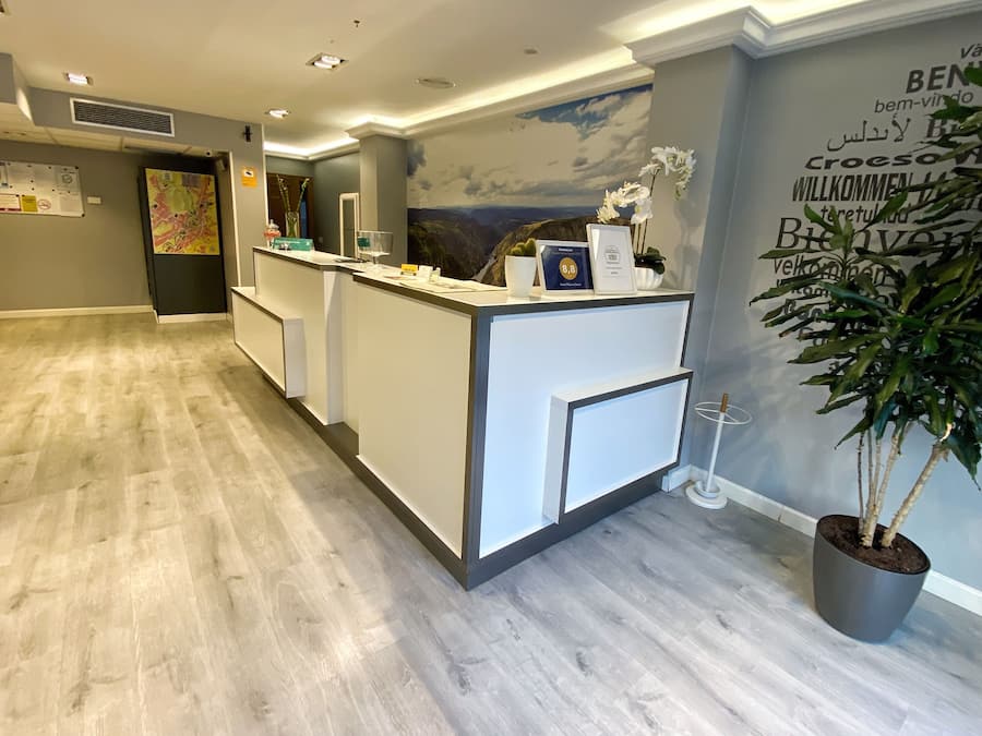 A reception area with a modern design, featuring a reception desk, a wall-mounted map, and a potted plant.