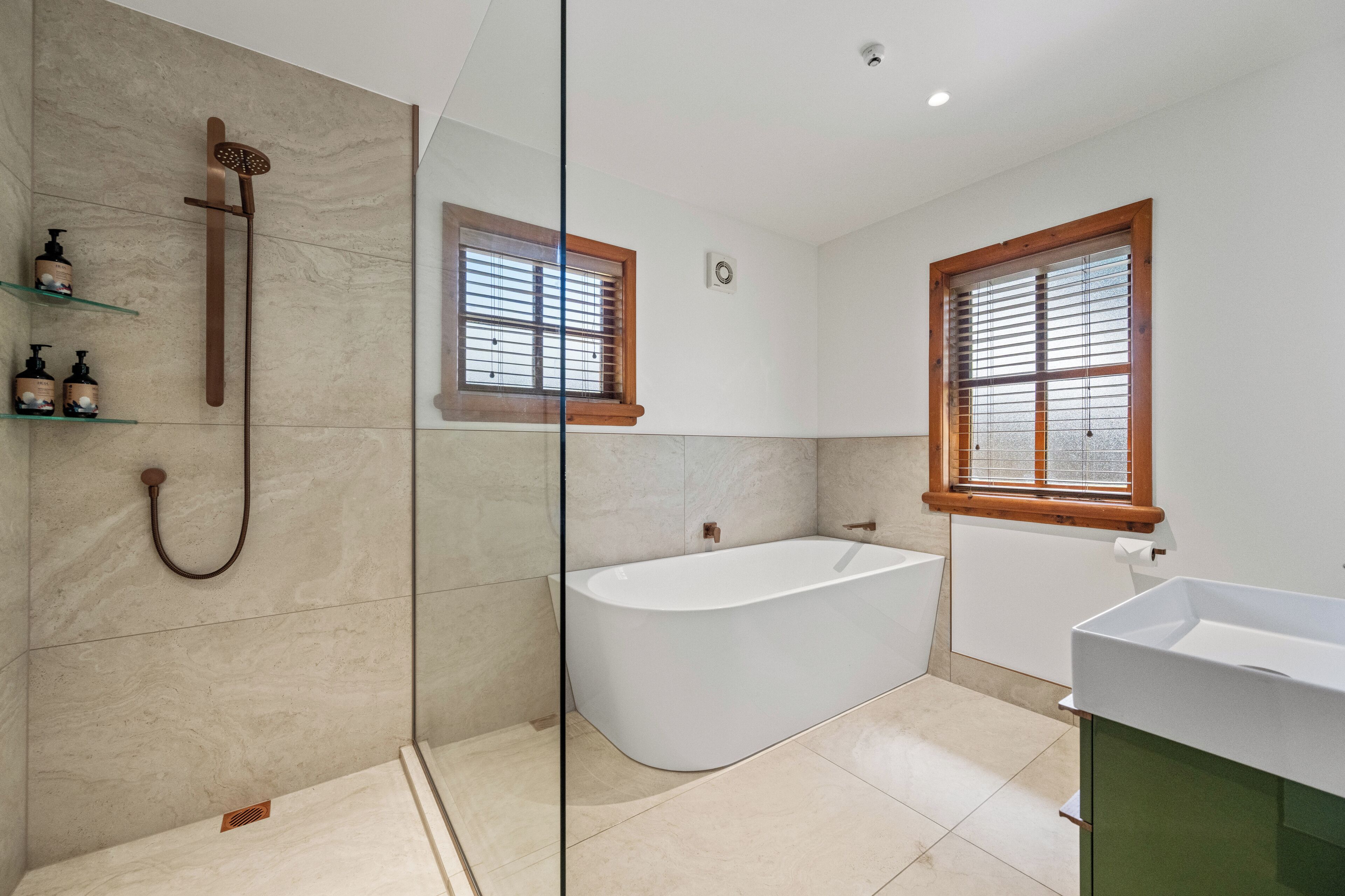 A modern bathroom with a freestanding bathtub, a glass shower enclosure, and a vanity with a sink.