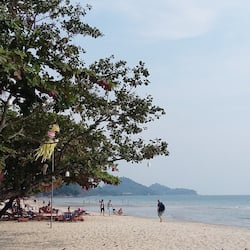 On the beach, white sand, sun-loungers, beach umbrellas