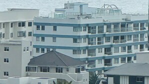 Complejo de edificios costeros con varios balcones y vista al mar.