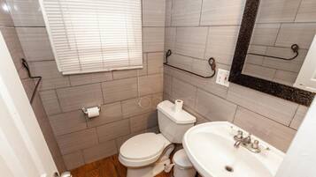 Une petite salle de bain avec des toilettes, un lavabo et un miroir.