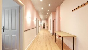 A hallway with wooden flooring, a bench, and a coat rack. - Hevals Grand Schöneberg (Berlin)