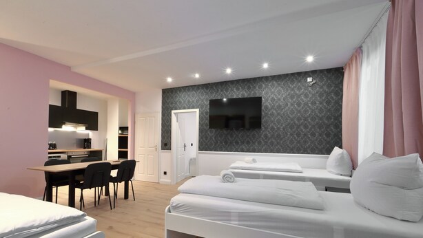 A modern hotel room with a bed, a desk, and a TV. - Hevals Grand Schöneberg (Berlin)