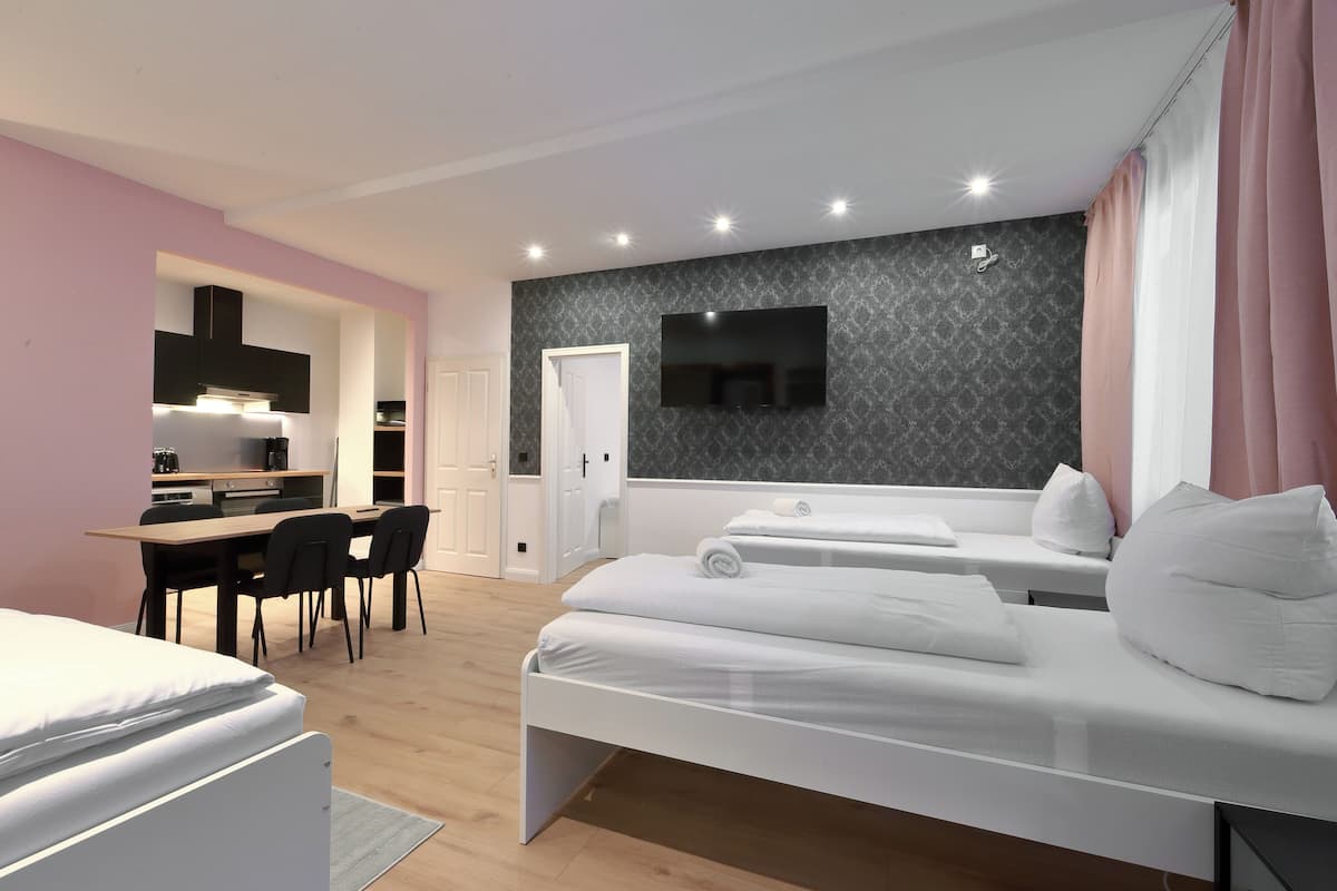 A modern hotel room with a bed, a desk, and a TV.