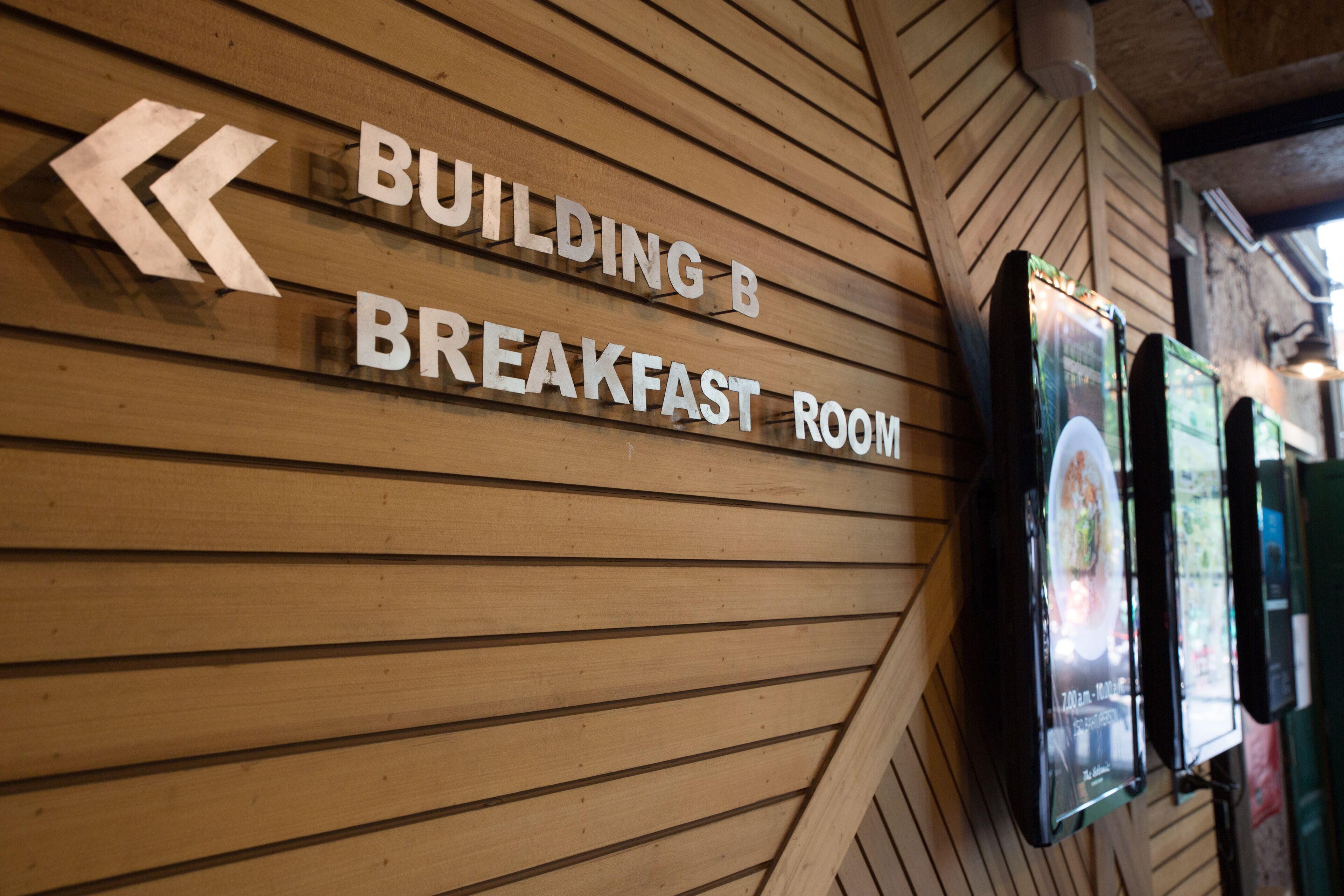 Pared de madera con señalización que indica la sala de desayunos del Edificio B.