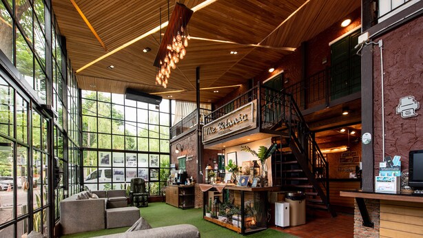 A spacious lobby with a high ceiling, large windows, and a staircase leading to an upper level. - The Botanic Service Room (Pak Kret)