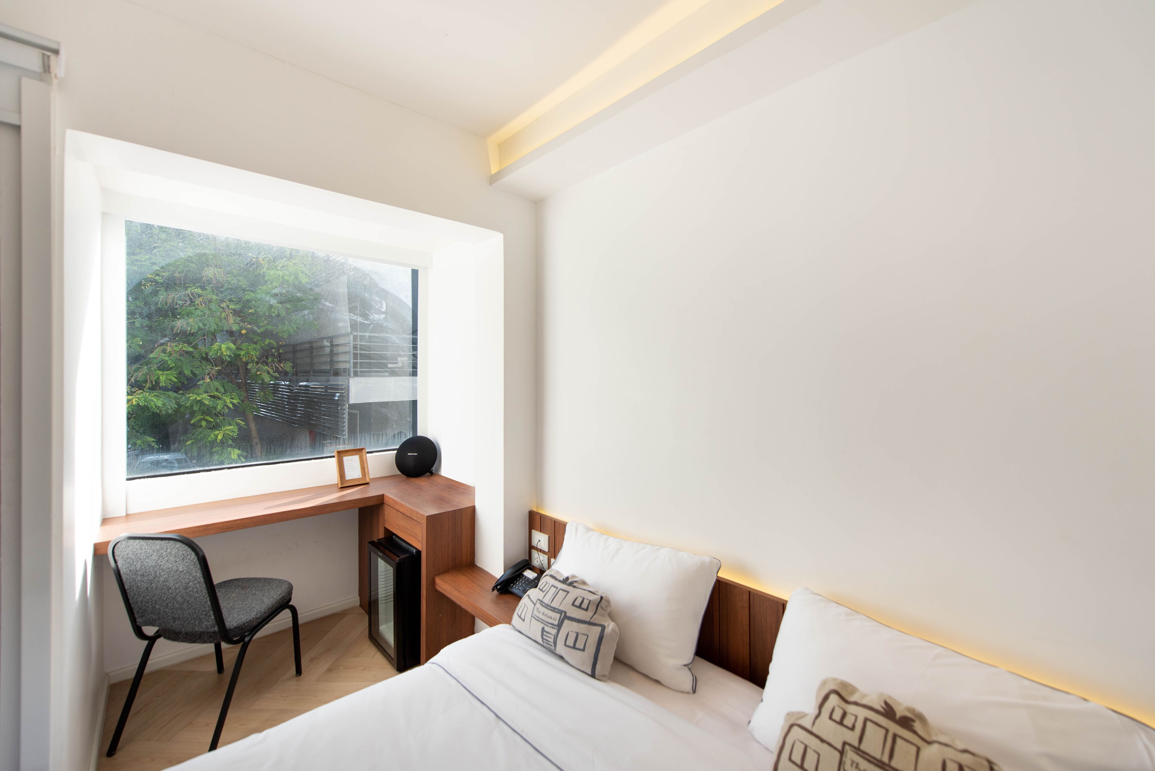 Una camera d'albergo moderna con scrivania, sedia e letto.