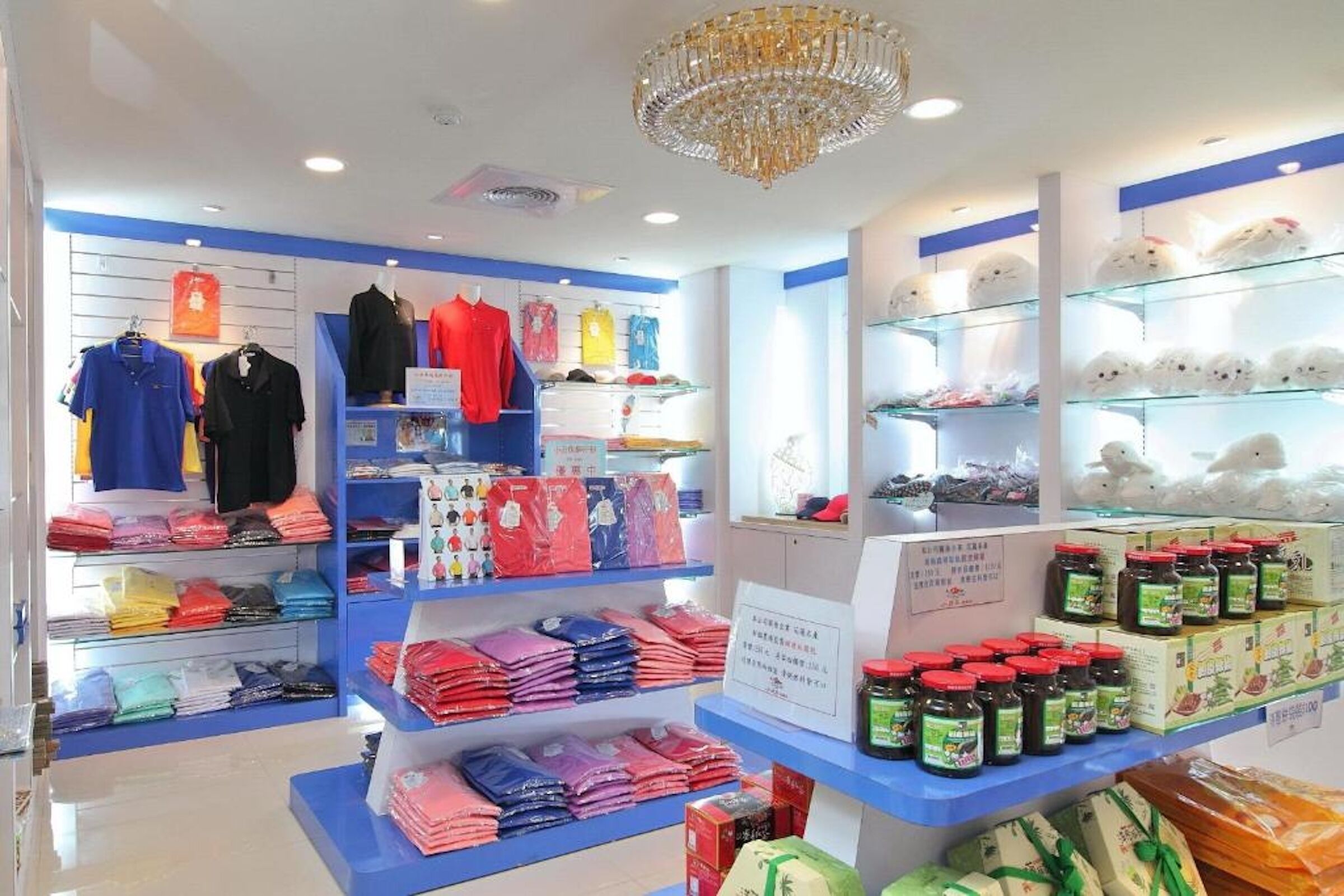 Una tienda minorista con ropa y accesorios a la vista, incluyendo prendas dobladas y productos en cajas.