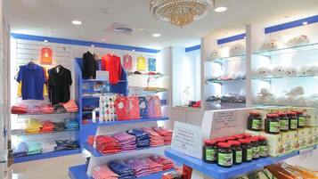 Una tienda minorista con ropa y accesorios a la vista, incluyendo prendas dobladas y productos en cajas.
