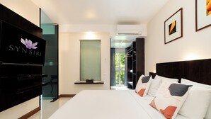 Una habitación de hotel moderna con una cama grande, televisión y vistas al exterior.
