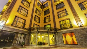 A multi-story hotel with a central courtyard, balconies, and a glass entrance. - The Monarch Hotel (Nairobi)