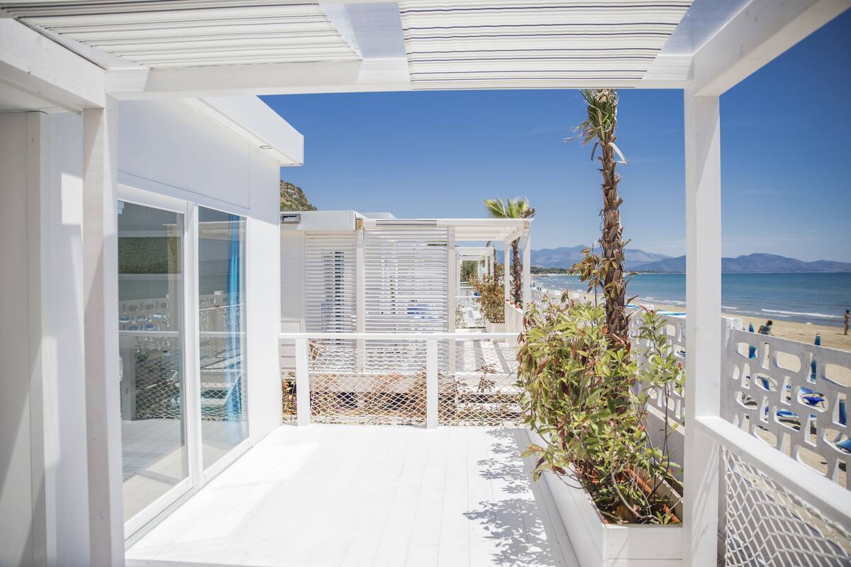 A balcony with a view of the beach and mountains.