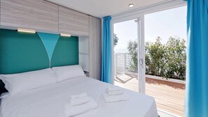Une chambre d’hôtel avec un lit, une vue sur l’extérieur et un balcon.