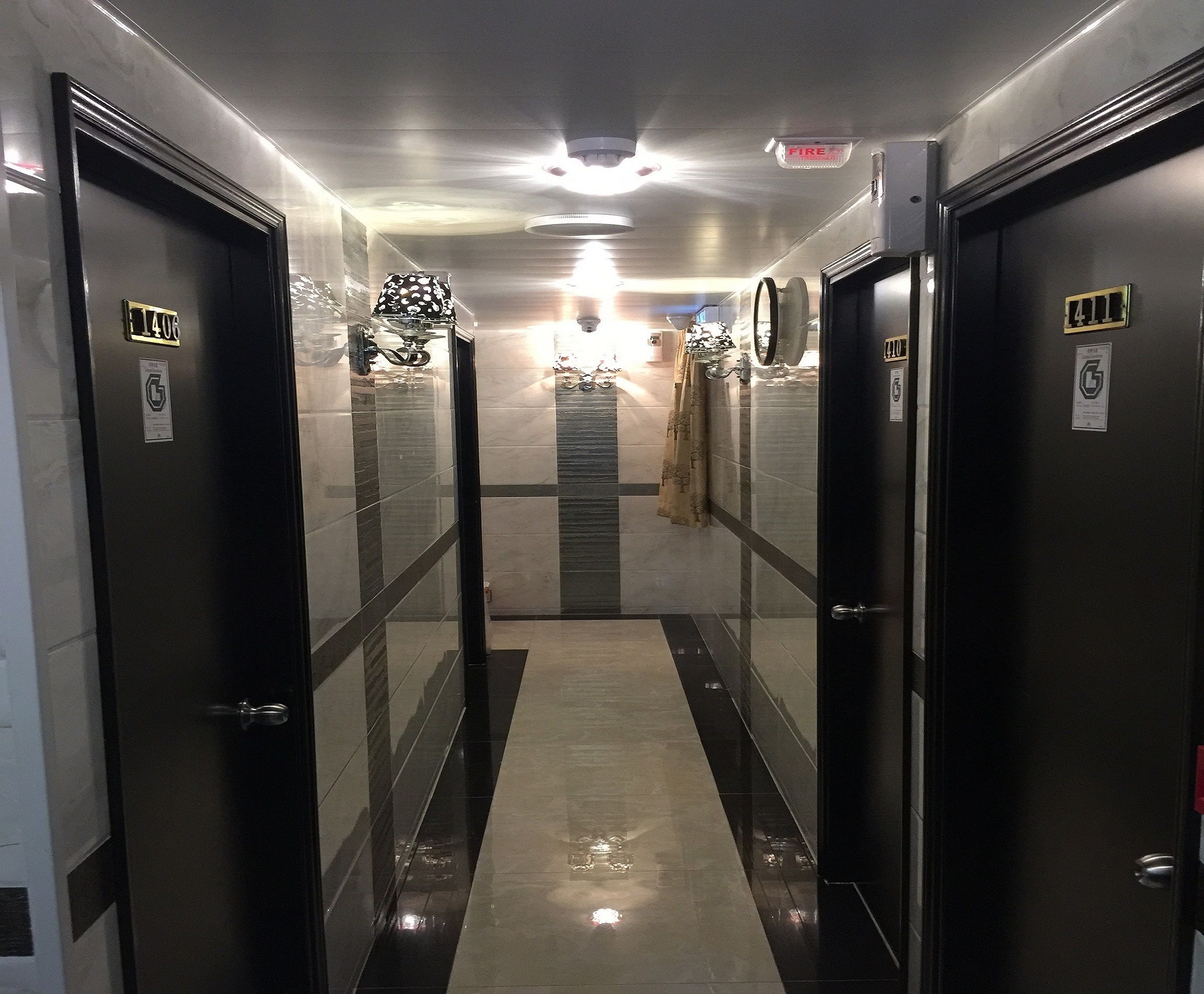 Un couloir avec des portes portant les numéros 401 et 410, un miroir et un détecteur d’incendie.