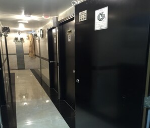 A corridor with black doors, a fire alarm, and a sign indicating a fire door to be kept closed. - Skylark Hostel (Kowloon)