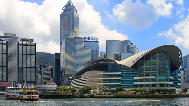 Un paisaje urbano moderno con edificios destacados, incluyendo un cartel de Philips, un edificio curvo singular y un rascacielos alto.