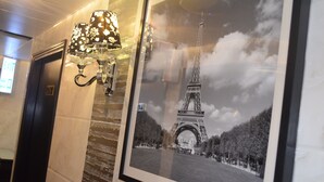 Una foto en blanco y negro enmarco, de la Torre Eiffel con una lámpara decorativa fijada a la pared.