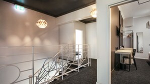Een modern interieur met een trap, een bureau en een spiegel.
