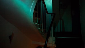 Una scala a chiocciola illuminata da una luce verde.