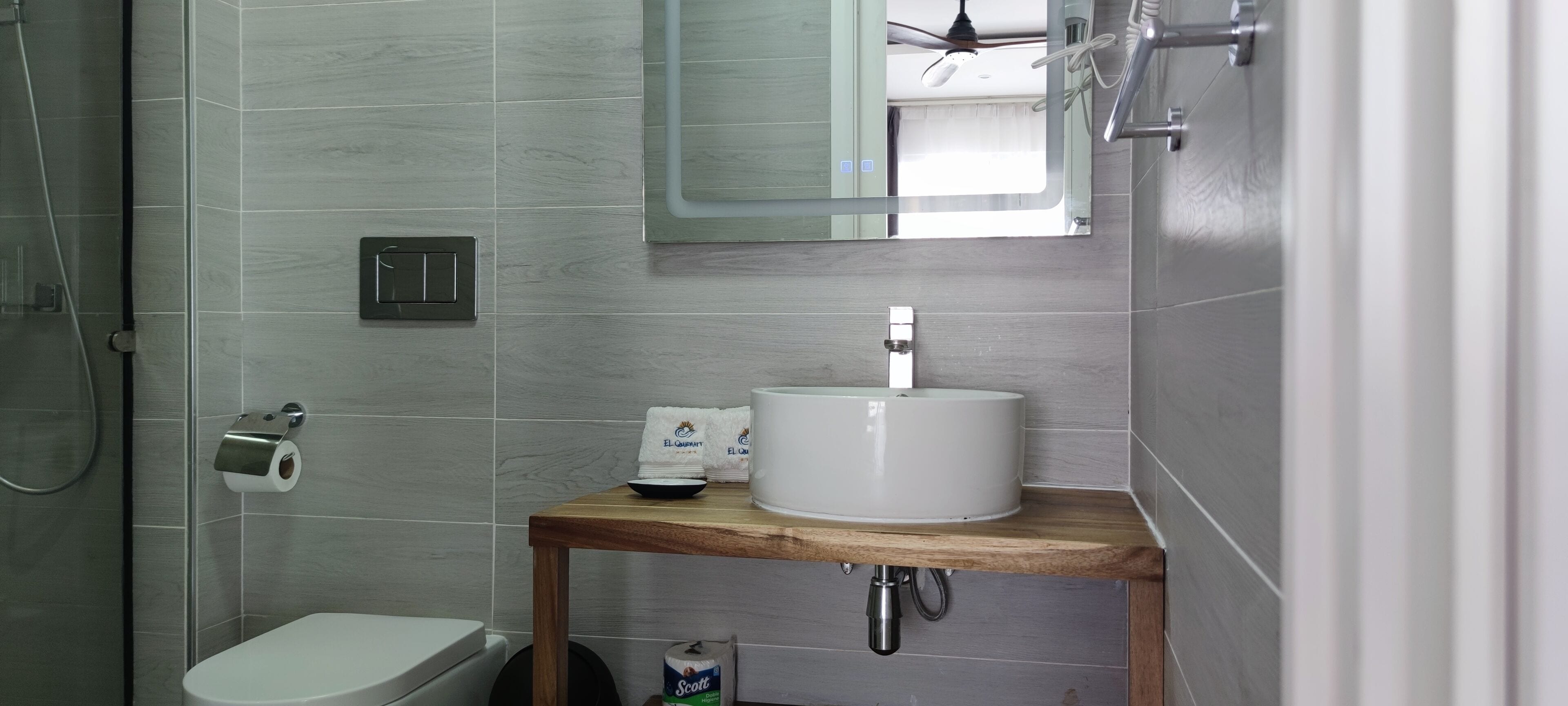 A modern bathroom with a toilet, sink, and shower.