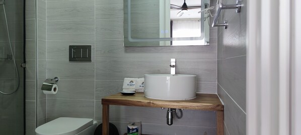 A modern bathroom with a toilet, sink, and shower.