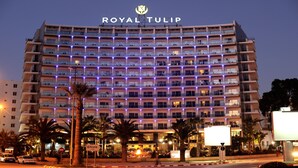 A multi-story hotel with balconies, palm trees, and a sign indicating it's an Encore hotel. - Royal Tulip City Center Tanger (Tangier)