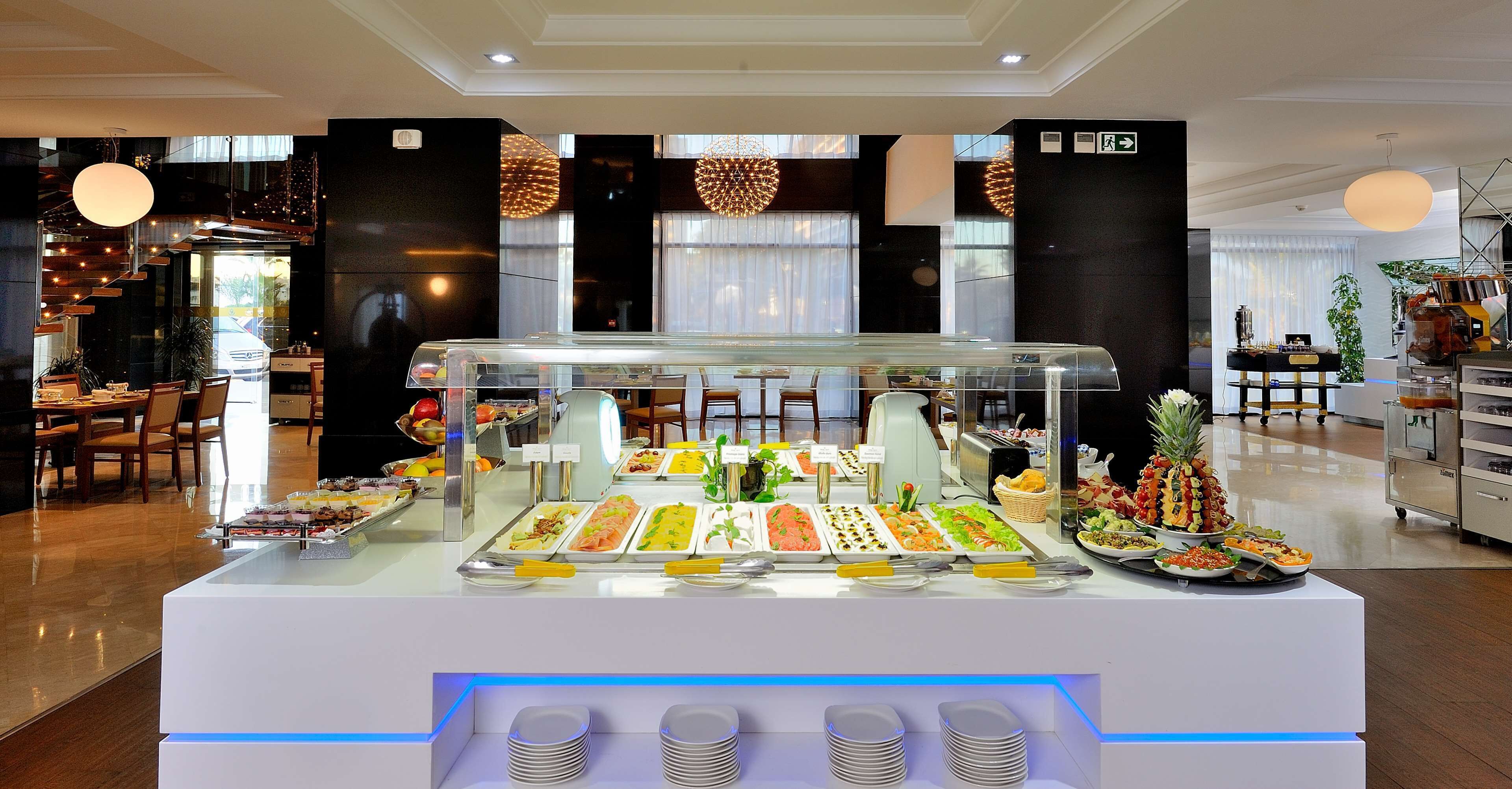 A buffet area with various food options, a seating area, and a staircase leading to an upper level.