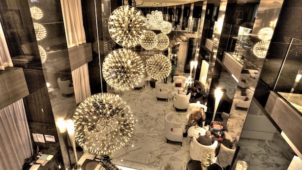 A modern lobby with large spherical chandeliers, marble flooring, and white seating areas. - Royal Tulip City Center Tanger (Tangier)